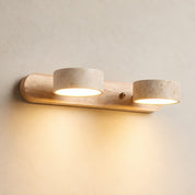 Two-light wooden wall sconce with speckled stone shades casting a warm glow.