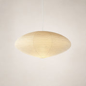 Warm ribbed paper pendant lamp with a wide oval shade hanging from a white cord.