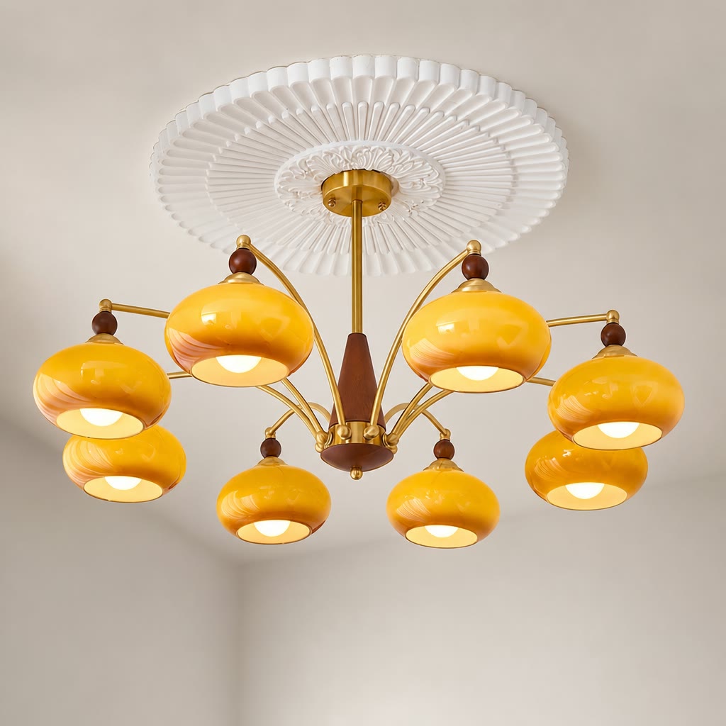 Yellow glass multi-arm chandelier with brass arms, wooden accents, and a white ceiling medallion.