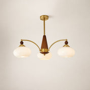 Three-light brass and wood chandelier with cream glass shades on a plain light background.