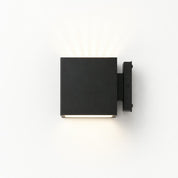 Matte black square exterior wall light with warm glow mounted on a right-side bracket.