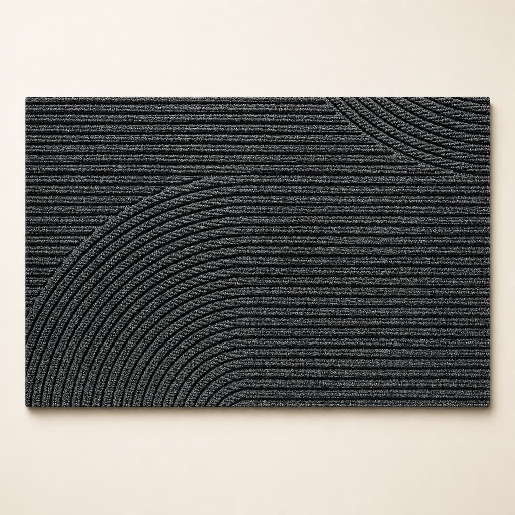 Charcoal rectangular ribbed rug with raised curved arc patterns on a light surface.