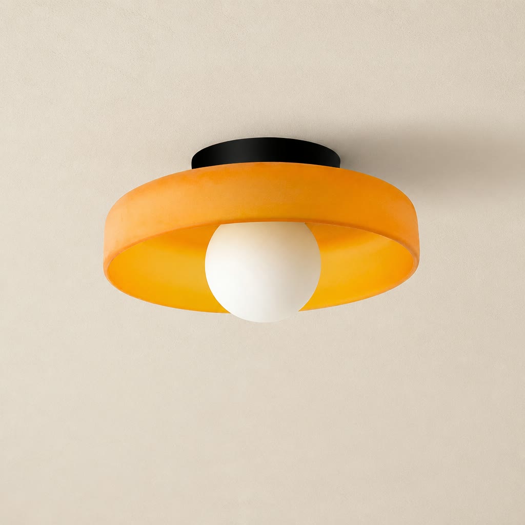 Orange ceiling light with black mount and white globe bulb on a neutral ceiling.