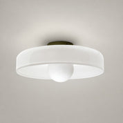 White flush mount ceiling light with round translucent shade and central frosted dome on a pale gray background.