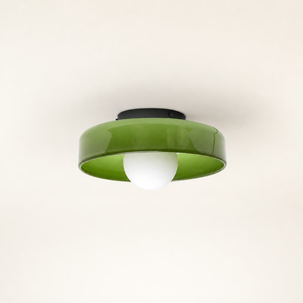 Glossy green ceiling light with a white globe bulb and black mount on a plain background.