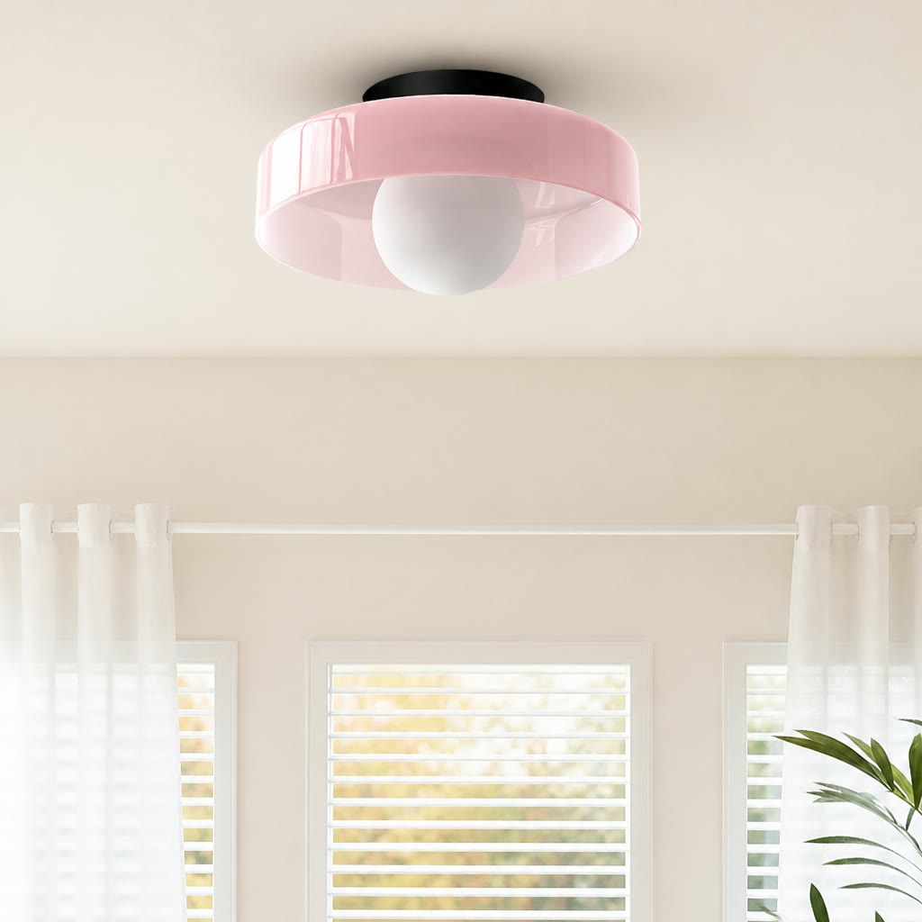 Glossy pink ceiling light with a round white bulb in a softly lit room.