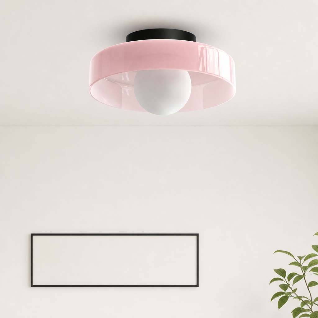 Pink flush mount ceiling light with a white globe bulb and black ceiling cap.