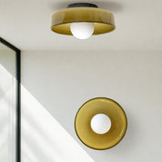 Two glossy amber ceiling lights with round white bulbs in a minimalist interior.