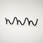 Black wavy metal wall hook rack with screw mounts on a clean white background.
