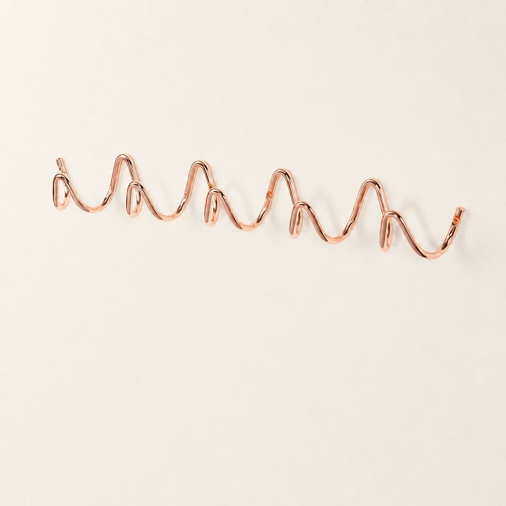 Rose gold wavy wall rack with multiple rounded hooks on a clean white surface.