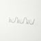 White wavy wall-mounted hook rail on a plain white textured wall.