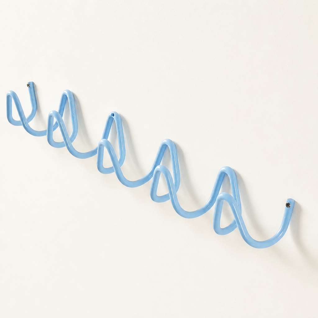 Light blue wavy wall-mounted hook rail on a plain white wall.