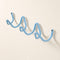 Light blue wavy wall-mounted hook rack with screw caps on a plain wall.