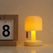 Warm cream mushroom table lamp with a red tag beside a wooden calendar block.