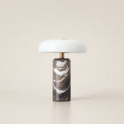 White dome table lamp with brass stem and dark brown marble cylindrical base.