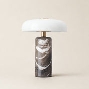 White dome table lamp with brass stem and dark marble cylindrical base.