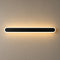 Long black rounded wall light with a white rim casting a warm glow.
