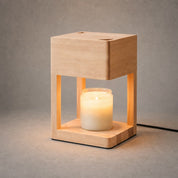 Wooden lantern frame holding a glowing glass jar candle on a neutral tabletop.