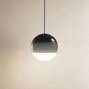 Glossy spherical pendant lamp with a black cord and shaded glass globe.