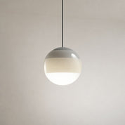 Glossy spherical pendant light with a black cord and warm glowing white lower half.