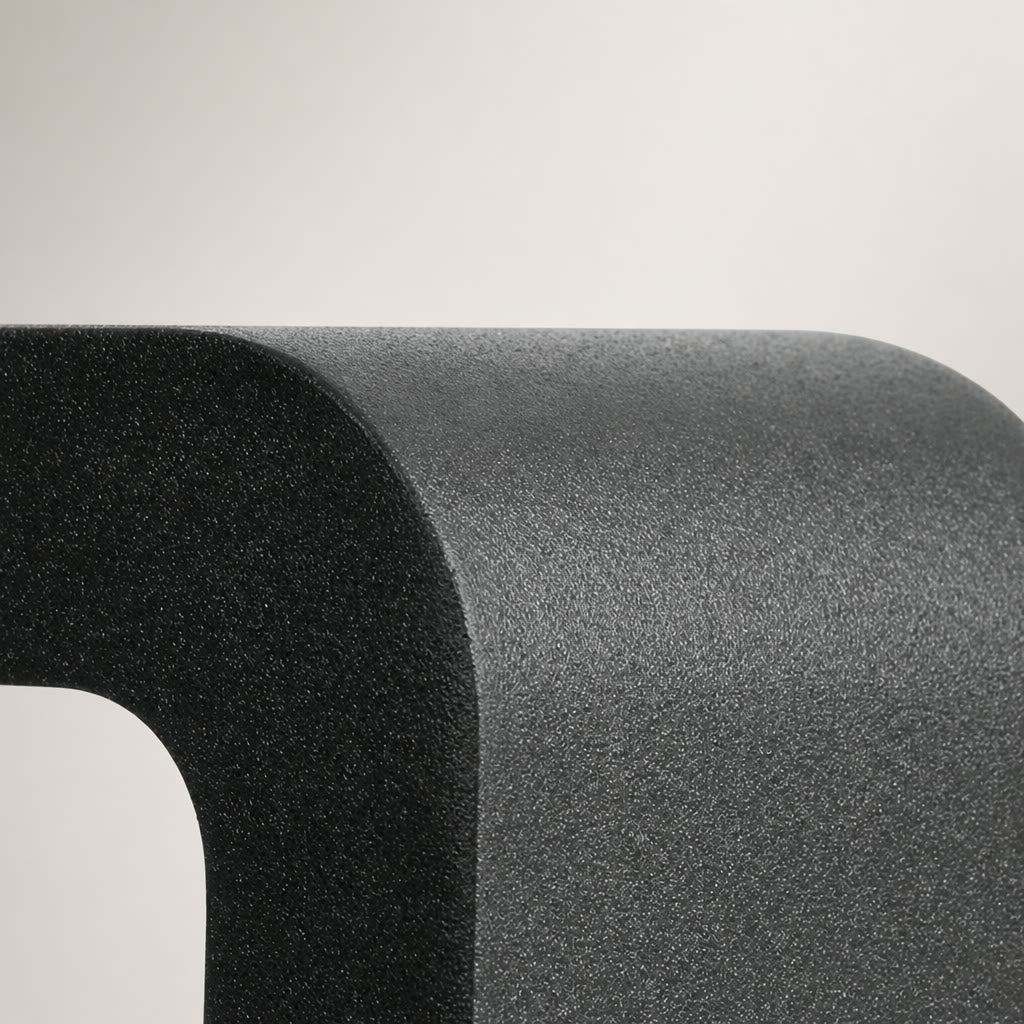 Close-up of a rounded dark gray textured product corner on a pale gray background.