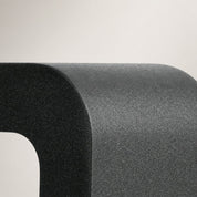 Close-up of a rounded dark gray textured product corner on a pale gray background.