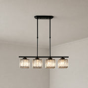 Black four-light linear pendant with glowing ribbed glass shades on a pale corner ceiling.