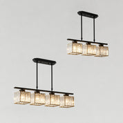 Black linear crystal pendant chandeliers with warm glowing cube shades on a gray background.