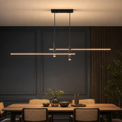 Black linear pendant light with warm glowing LED bars above a modern dining table.