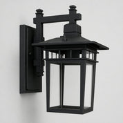 Black outdoor wall lantern sconce with clear glass panels on a plain light background.