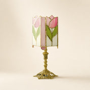 Pink tulip stained glass table lamp with ornate gold base on a pale neutral background.