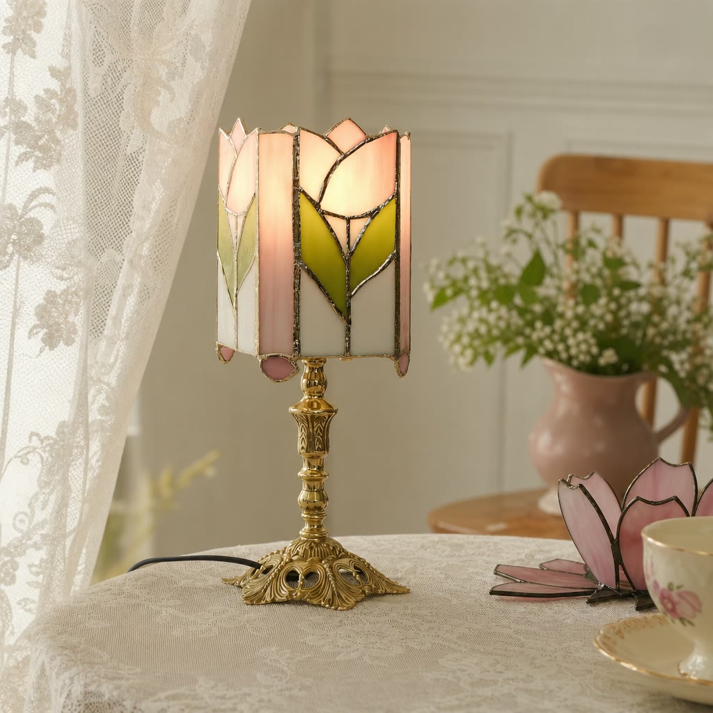 Glowing tulip stained glass table lamp with pink and green panels on an ornate gold stand.