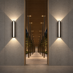 Two black vertical wall sconces cast warm light on textured walls flanking a modern corridor.