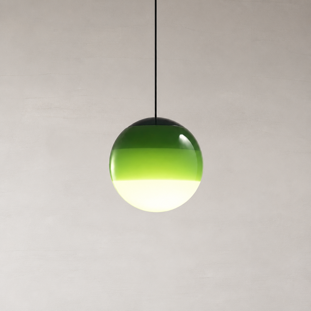 Green glass globe pendant light hanging from a black cord against a pale minimalist wall.