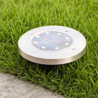 Round stainless steel solar garden light with solar panel set in grass.
