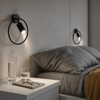 Black circular wall-mounted reading lamps illuminate a modern bedside scene.