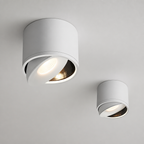 Two white adjustable cylindrical ceiling spotlights with warm glowing recessed bulbs.