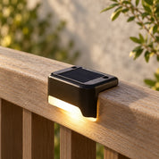 Close view of the solar panel and continuous lower light window on a fence rail.
