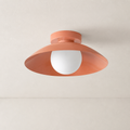 Coral ceiling light with wide saucer shade and white globe bulb on a pale ceiling.