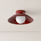 Glossy dark red ceiling light with a wide curved shade and white globe bulb.