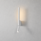 White minimalist wall sconce with vertical tube and angled spotlight glowing on a pale gray wall.