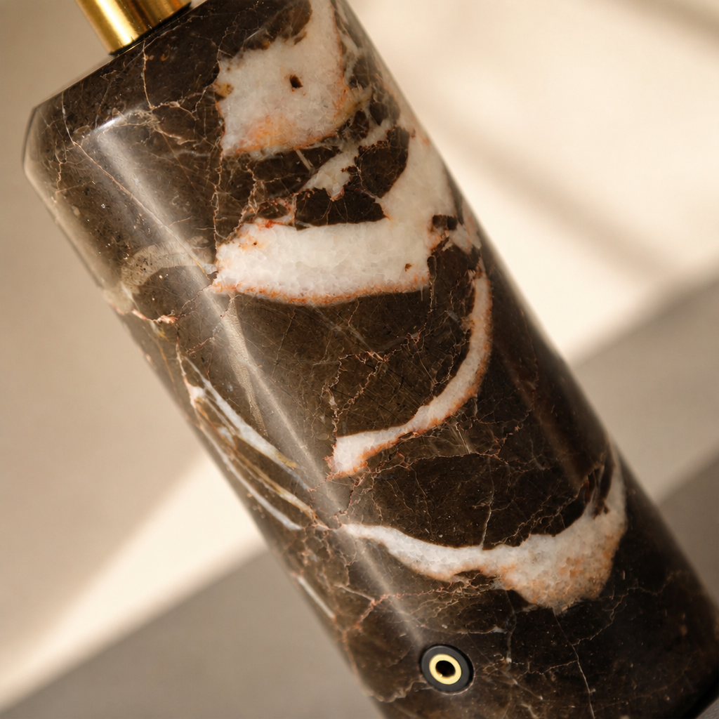 Brown marble cylindrical product with white veining and a brass port.