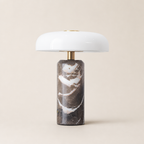 White dome table lamp with brass stem and dark marble cylindrical base.