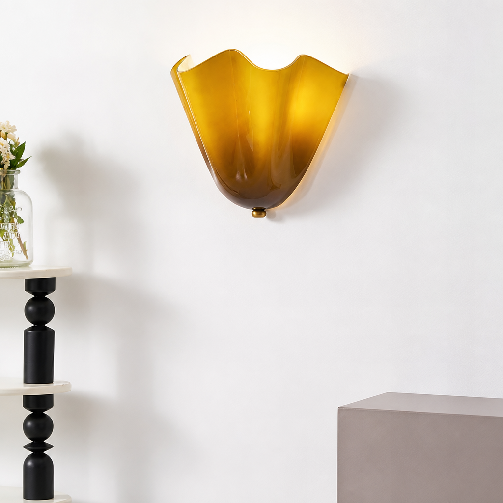 Amber wavy glass wall sconce mounted on a minimalist white wall.