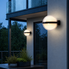 Two glowing round outdoor wall lights with black bands on a modern exterior wall.