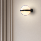 Glowing round wall sconce with a black horizontal band on a pale wall.