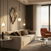 Modern living room with gold teardrop pendant lights above a beige sofa and marble tables.