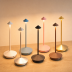 Seven colorful mushroom-shaped table lamps glow on a wooden surface.