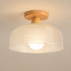 Warm glowing ceiling light with a wood mount and cream woven drum shade.