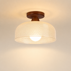Warm ceiling light with a woven beige shade and wooden mount against a plain ceiling.